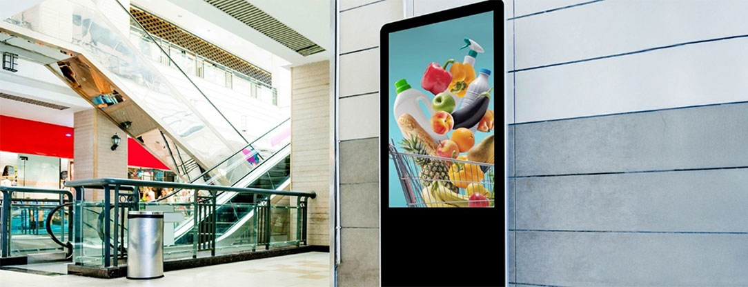 Egy áruval tömött bevásárlókosarat ábrázoló beltéri fali reklám egy pláza lépcsőháza mellett